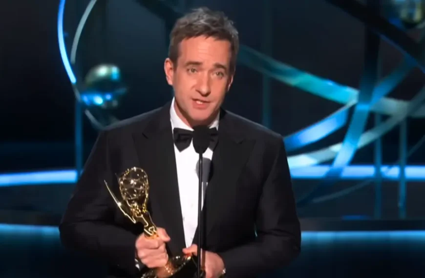 A person in black suits confidently holds the prestigious Emmy Awards 2024 in his hand